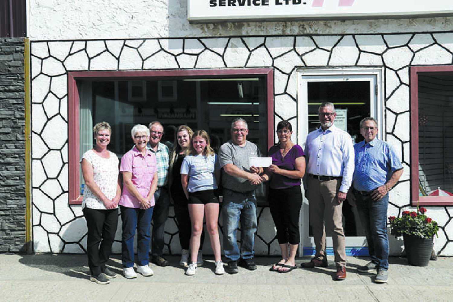 The Glasser family presents Moosomin Airport a cheque for $20,000. From left to right, Kari Meyers, Carol and Wayne Glasser, Niquitta and Zoe Goliboski, John Glasser, Kendra Lawrence, Schalk Van der Merwe, and Jeff St. Onge.